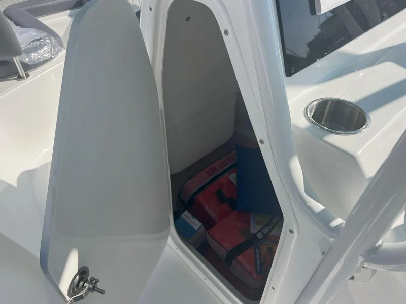 Slide: The Image of Open storage compartment on Reflex Gladiator 2400 boat, showing life jackets and cup holder. - 20