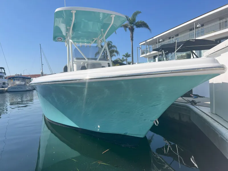 Slide: The Image of 2026 Reflex Gladiator 2400 boat docked, turquoise hull, sunny marina setting. - 4