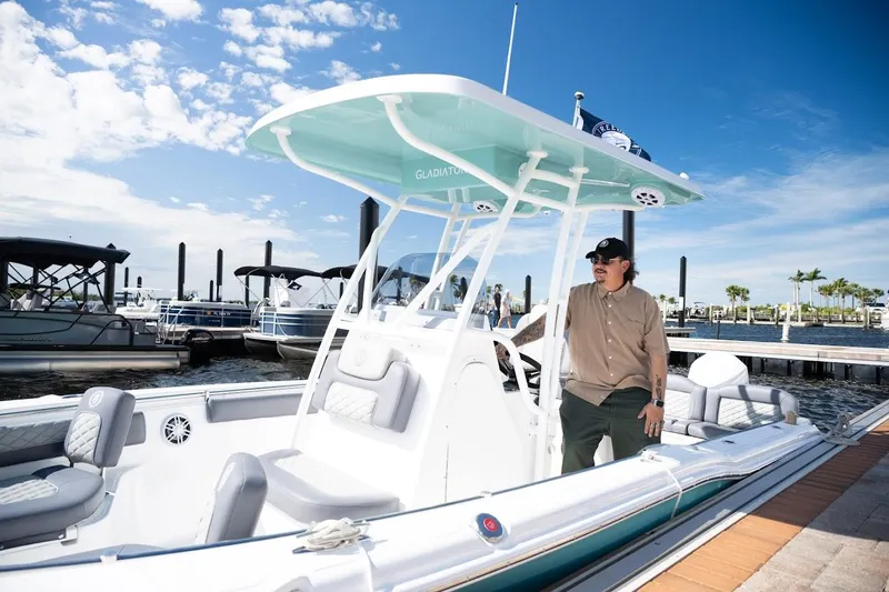Slide: The Image of Man standing on a 2026 Reflex Gladiator 2400 boat at a marina. - 5