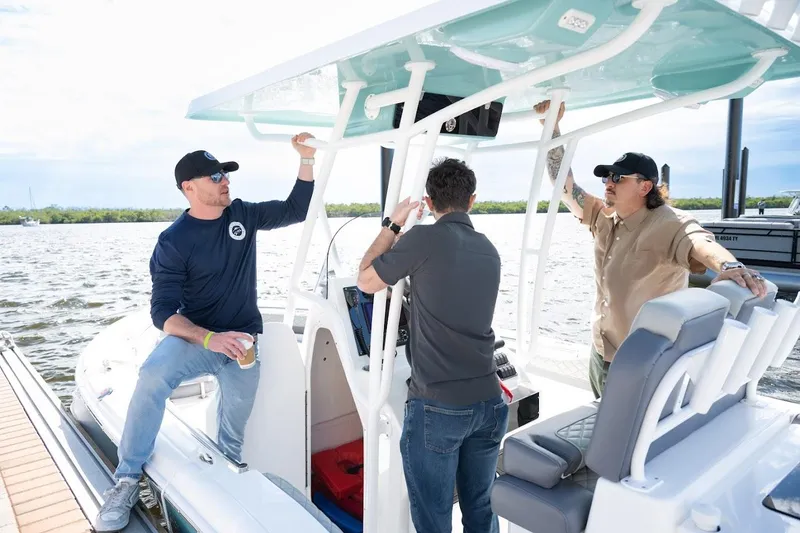 Slide: The Image of Three men on a 2026 Reflex Gladiator 2400 boat, enjoying a sunny day on the water. - 6
