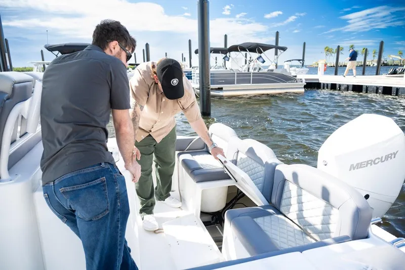 Slide: The Image of Two people inspecting a 2026 Reflex Gladiator 2400 boat at a marina. - 7
