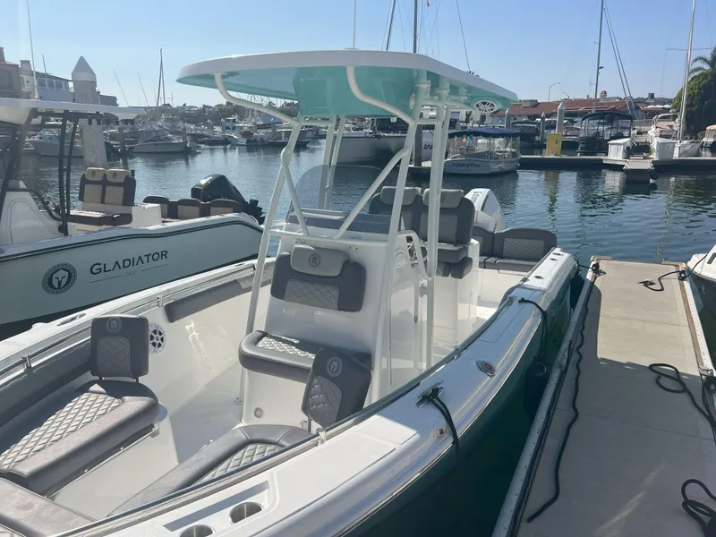 Slide: The Image of 2026 Reflex Gladiator 2400 boat docked in a marina, featuring modern seating and design. - 8