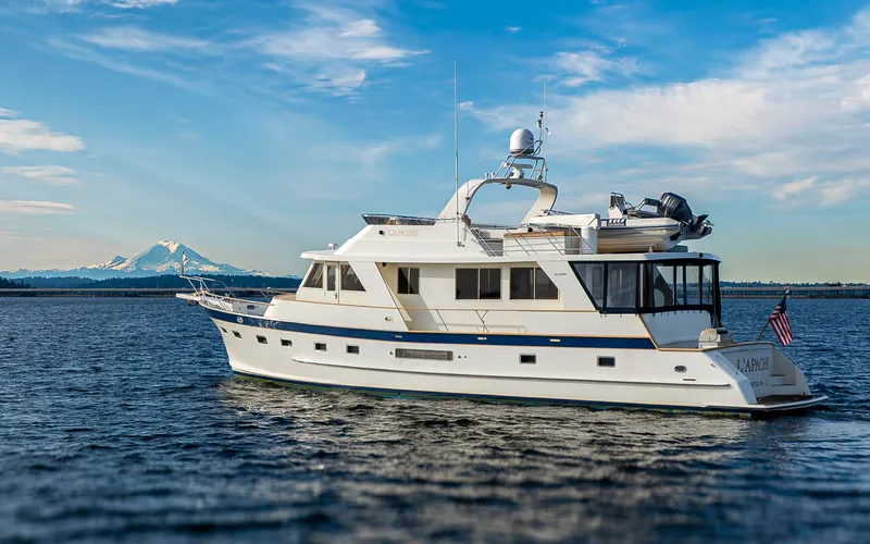 Slide: The Image of 2006 Alaskan 65 Flushdeck yacht on open water with mountain backdrop. - 2