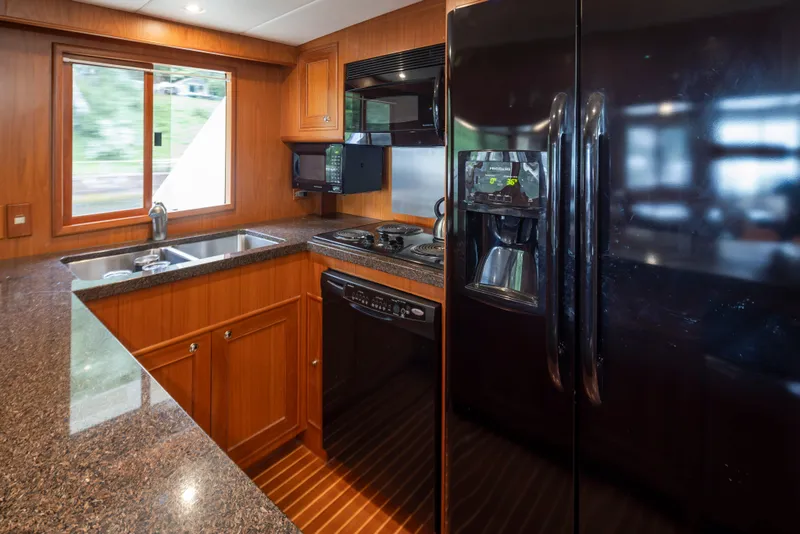 Slide: The Image of Luxurious kitchen in 2006 Alaskan 65 Flushdeck yacht with modern appliances and wood cabinetry. - 21