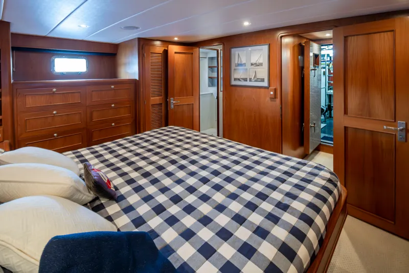 Slide: The Image of Luxurious cabin interior of 2006 Alaskan 65 Flushdeck yacht with checkered bedding and wooden furnishings. - 25