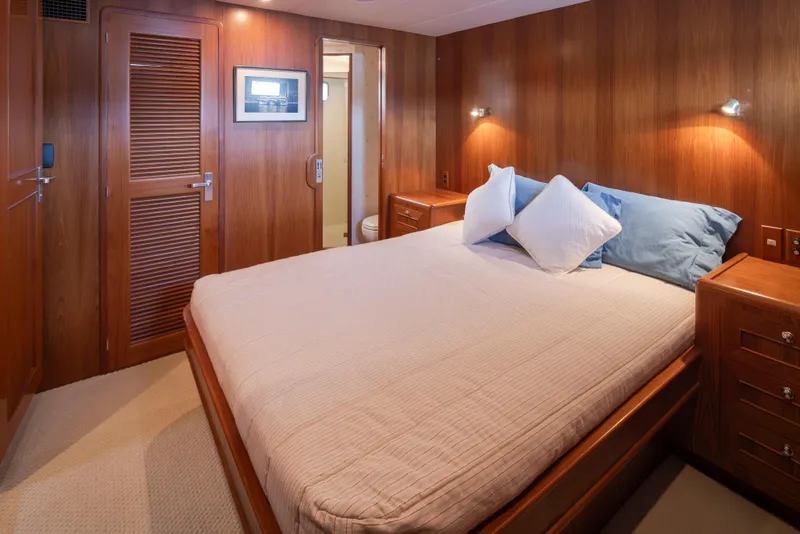 Slide: The Image of Luxurious bedroom interior on 2006 Alaskan 65 Flushdeck yacht, featuring wood paneling and cozy bedding. - 34