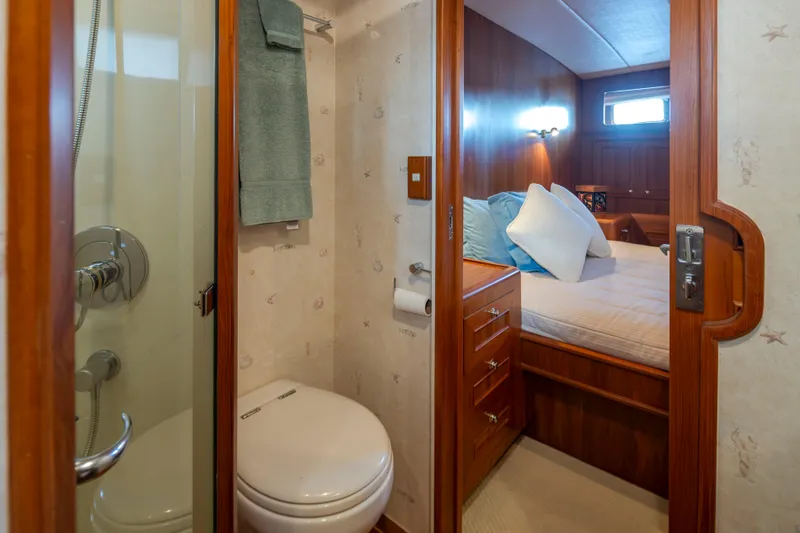 Slide: The Image of Bathroom and bedroom interior of 2006 Alaskan 65 Flushdeck yacht, featuring wood finishes. - 37