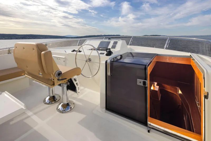 Slide: The Image of 2006 Alaskan 65 Flushdeck yacht helm with tan seating and open cabin entrance. - 46