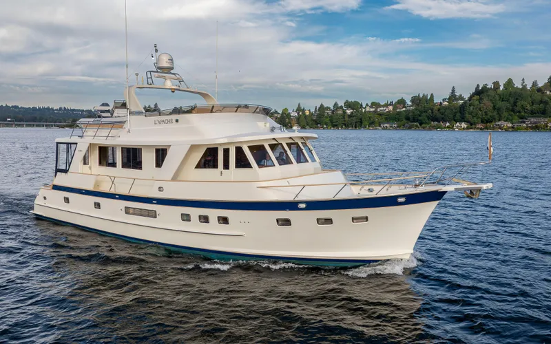 Slide: The Image of 2006 Alaskan 65 Flushdeck yacht cruising on a scenic lake with lush shoreline. - 6