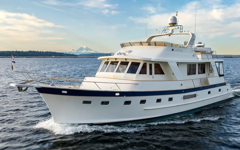 Slide: The Image of Luxury 2006 Alaskan 65 Flushdeck yacht cruising on open water, scenic mountain backdrop. - 7