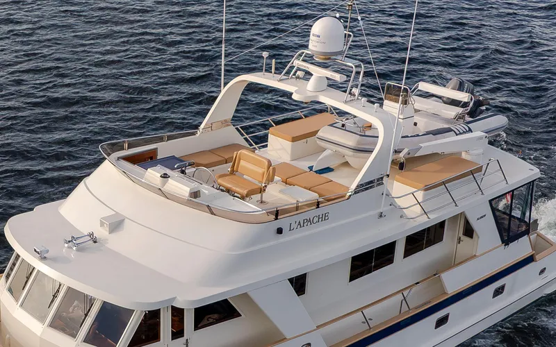 Slide: The Image of 2006 Alaskan 65 Flushdeck yacht cruising on water, featuring spacious deck and seating area. - 8