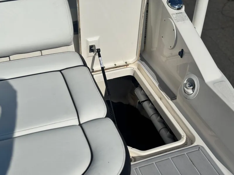 Slide: The Image of Open storage compartment on 2015 Sea Ray 270 SDX boat with cushioned seating. - 12