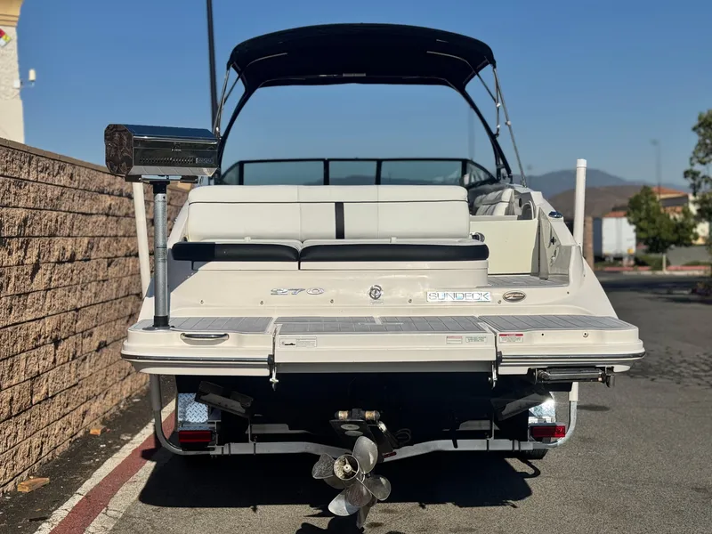 Slide: The Image of 2015 Sea Ray 270 SDX boat, rear view, parked on street with cover and grill. - 4
