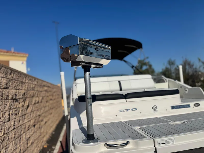 Slide: The Image of 2015 Sea Ray 270 SDX boat with grill, docked under clear blue sky. - 7