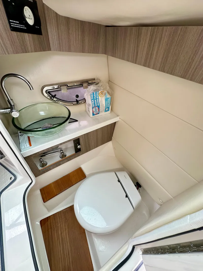 Slide: The Image of 2023 Regal 2800 Bowrider bathroom with modern sink, toilet, and wooden accents. - 10