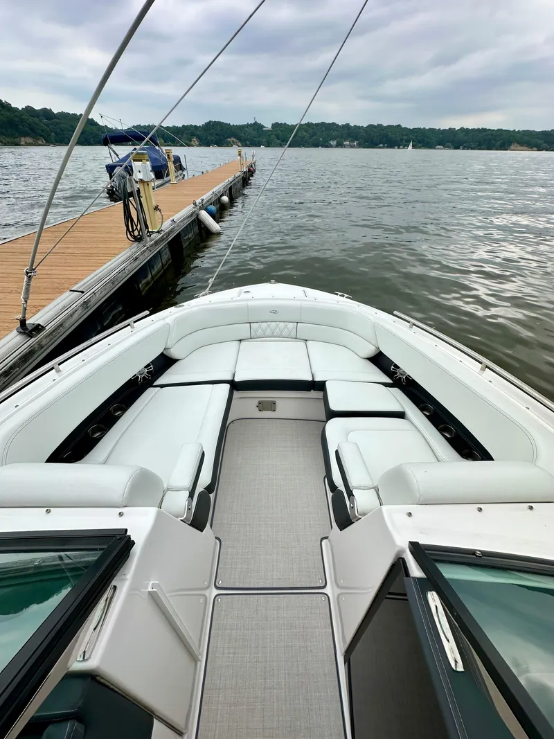 Slide: The Image of 2023 Regal 2800 Bowrider docked on a calm lake with spacious seating. - 15
