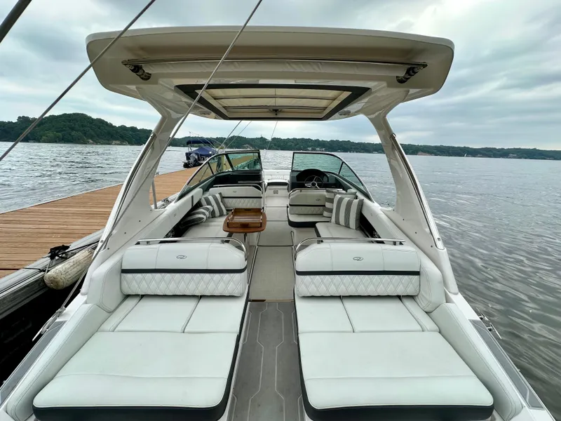 Slide: The Image of 2023 Regal 2800 Bowrider boat with luxurious seating, docked by a scenic lake. - 3