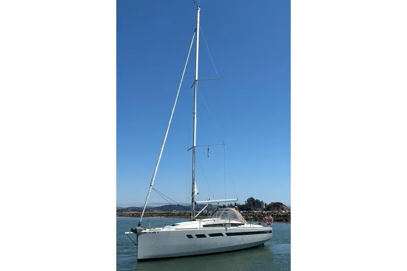 The Image of 2021 Jeanneau Sun Odyssey 349 sailboat on calm water under clear blue sky. - 0