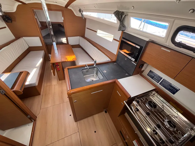 Slide: The Image of Interior of 2021 Jeanneau Sun Odyssey 349 sailboat with modern kitchen and seating area. - 11