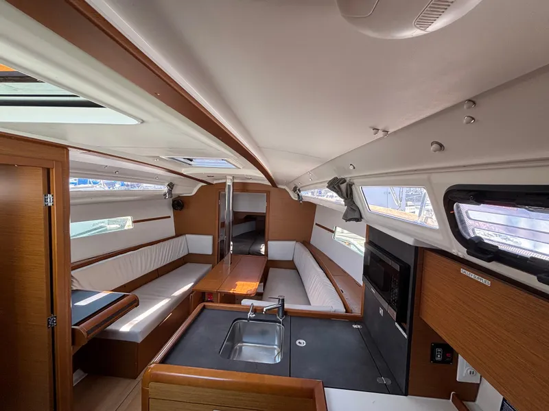 Slide: The Image of Interior of 2021 Jeanneau Sun Odyssey 349 sailboat, featuring modern kitchen and seating area. - 12