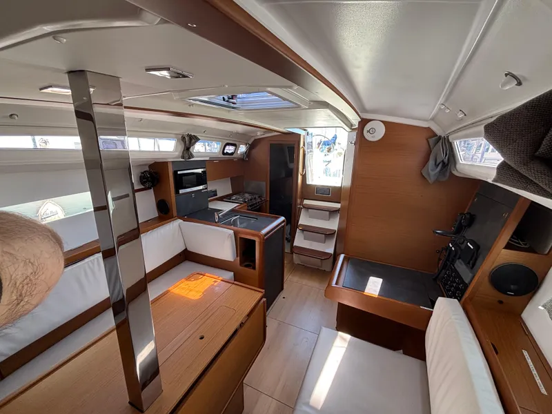 Slide: The Image of Interior of 2021 Jeanneau Sun Odyssey 349 sailboat, featuring modern wood finish and seating area. - 13