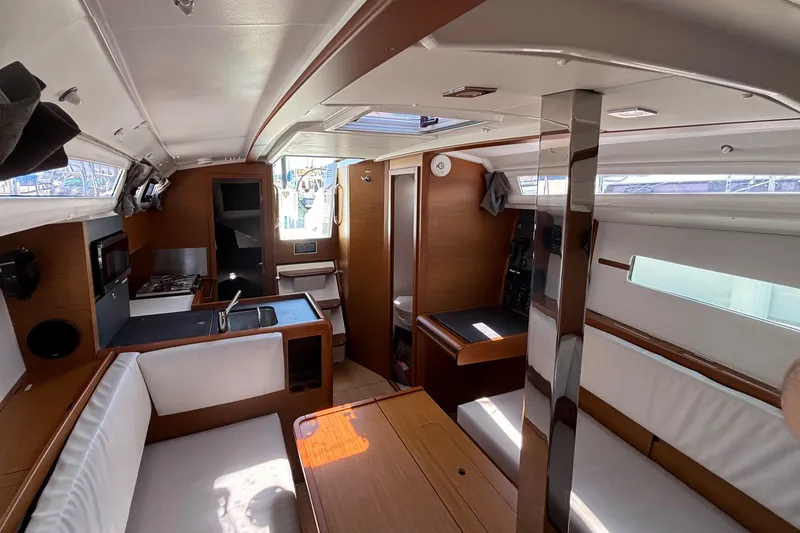 Slide: The Image of Interior of 2021 Jeanneau Sun Odyssey 349 sailboat, featuring modern kitchen and seating area. - 14