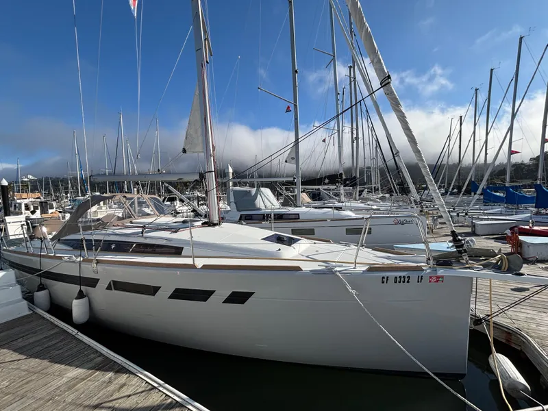 Slide: The Image of 2021 Jeanneau Sun Odyssey 349 sailboat docked at a marina under a clear blue sky. - 4
