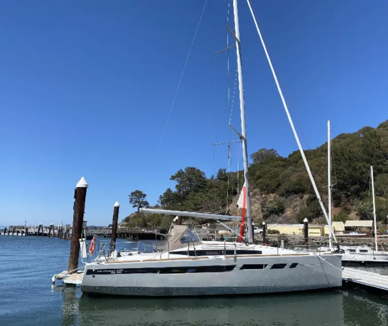 Slide: The Image of 2021 Jeanneau Sun Odyssey 349 sailboat docked in a marina under clear blue skies. - 6
