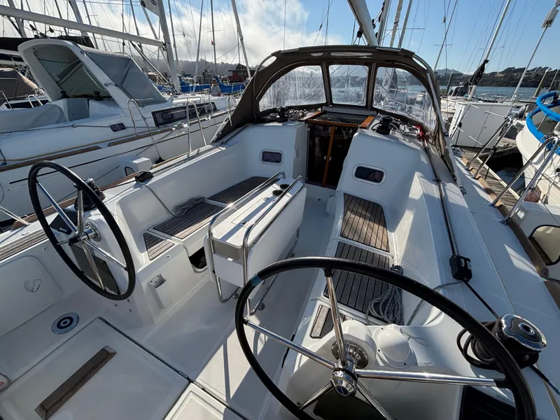 Slide: The Image of 2021 Jeanneau Sun Odyssey 349 sailboat cockpit with dual steering wheels in marina. - 7