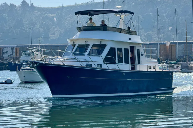 The Image of 2003 President Performance Trawler cruising in a marina with scenic background. - 0
