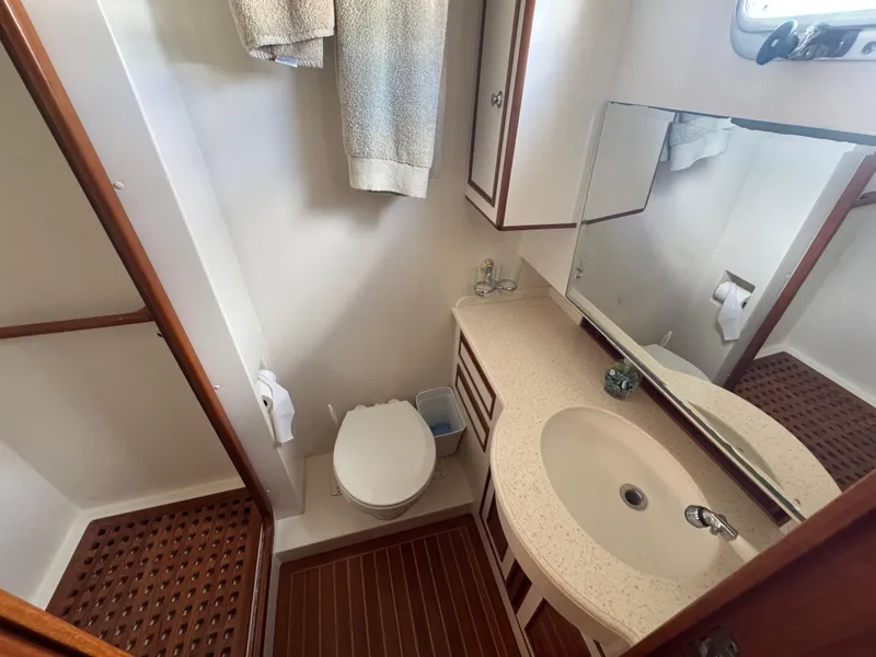 Slide: The Image of Bathroom interior of 2003 President Performance Trawler with sink, toilet, and wooden accents. - 10