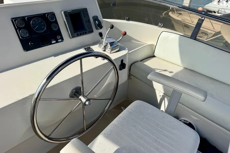 Slide: The Image of 2003 President Performance Trawler helm with steering wheel and navigation controls. - 16