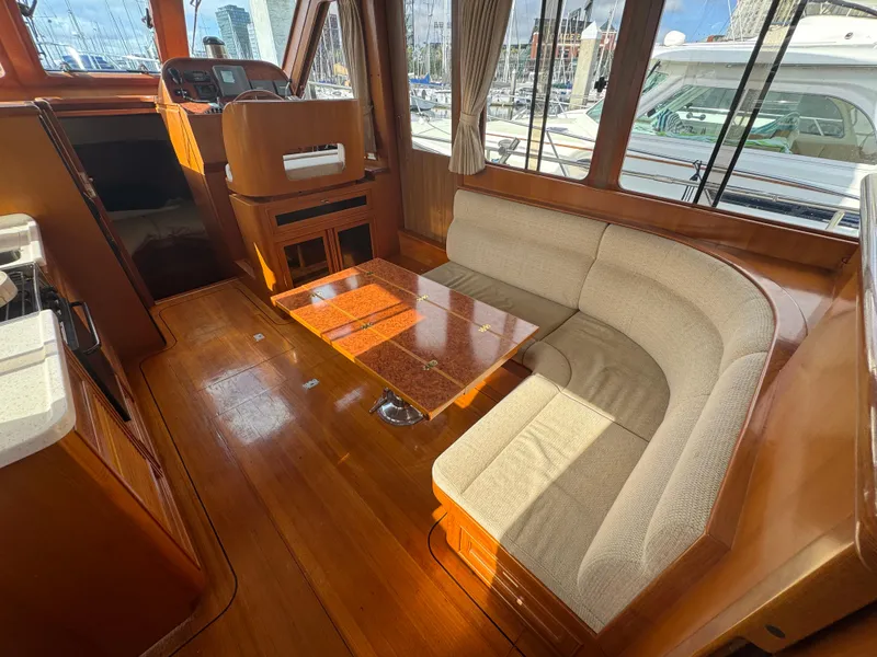 Slide: The Image of 2003 President Performance Trawler interior with wood finish and cushioned seating area. - 6