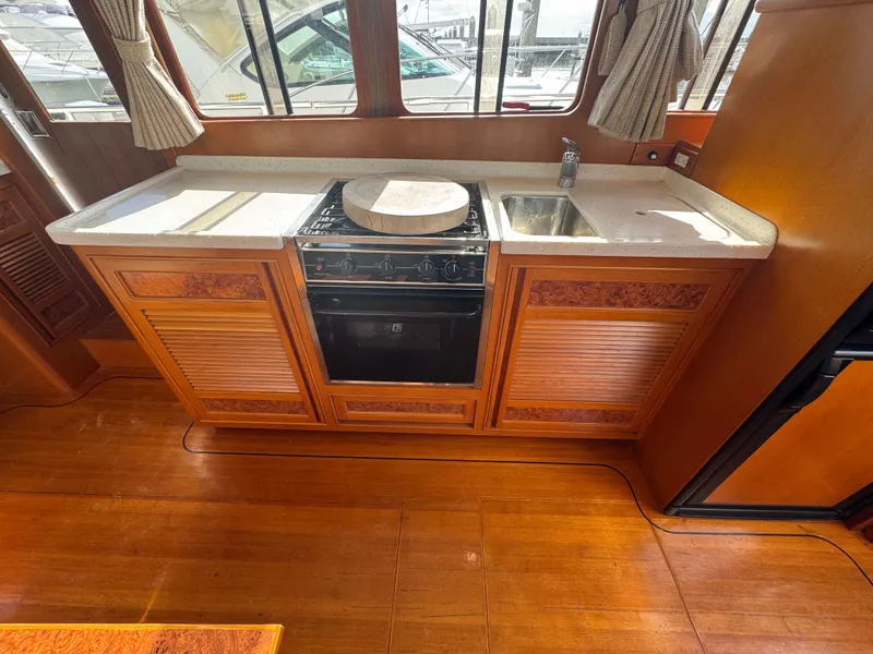 Slide: The Image of 2003 President Performance Trawler kitchen with stove, sink, and wooden cabinetry. - 7