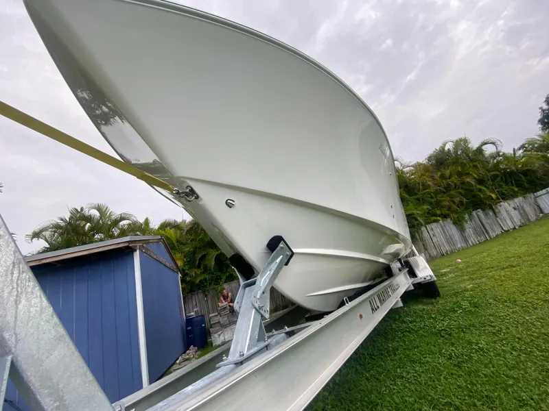 Slide: The Image of 2011 Mako 284 CC boat on trailer, parked on grass near blue shed. - 5