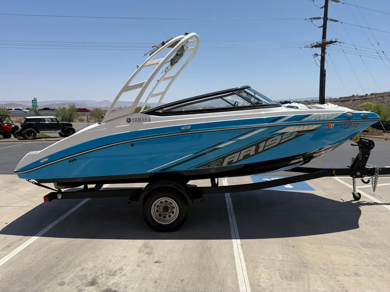 Slide: The Image of 2021 Yamaha AR195 boat on trailer, blue and white design, parked outdoors. - 10