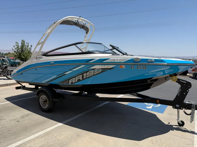 Slide: The Image of 2021 Yamaha Boats AR195 in blue on a trailer, parked outdoors. - 11