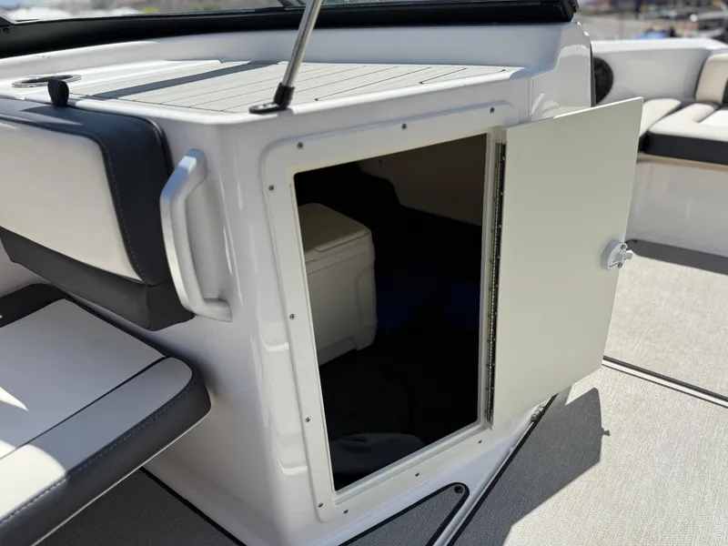 Slide: The Image of 2021 Yamaha AR195 boat storage compartment with open door, revealing interior space. - 29