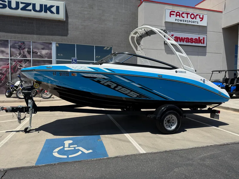 Slide: The Image of 2021 Yamaha AR195 boat on trailer at dealership, featuring blue and white design. - 3