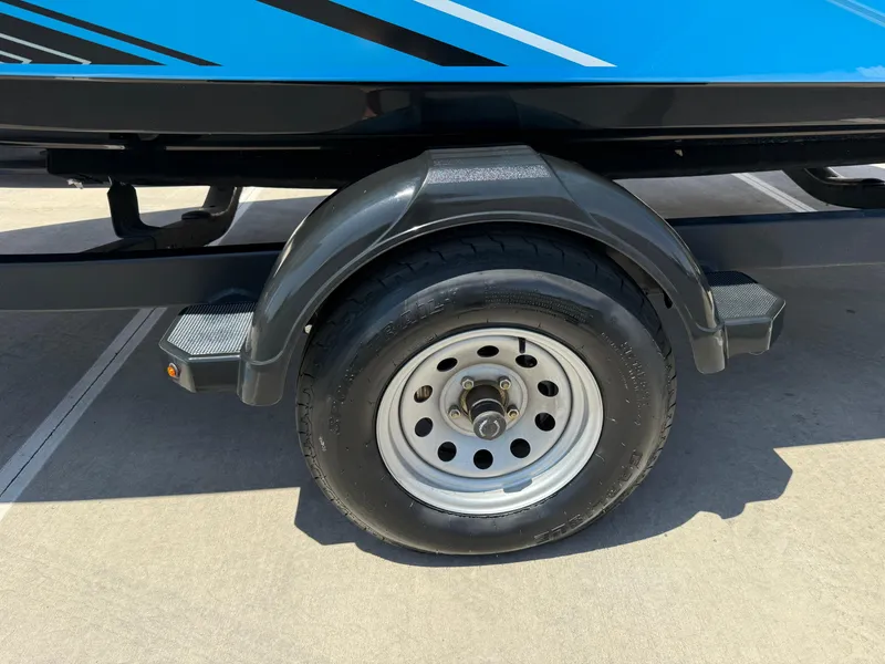 Slide: The Image of Trailer wheel of a 2021 Yamaha Boats AR195, featuring a sleek blue design. - 37