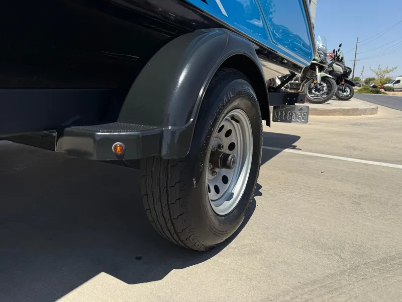 Slide: The Image of 2021 Yamaha Boats AR195 trailer tire on concrete pavement, with motorcycles in the background. - 38