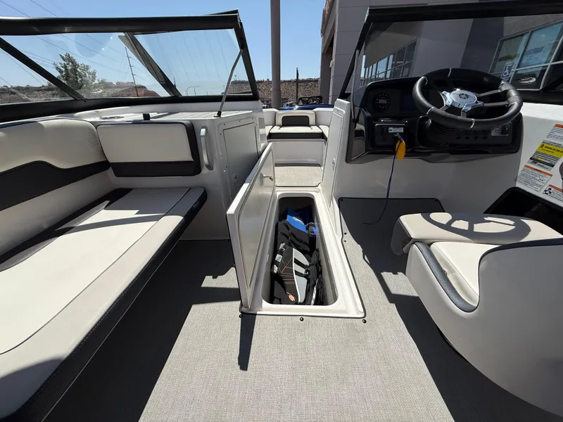 Slide: The Image of 2021 Yamaha Boats AR195 interior with open storage compartment and steering wheel. - 39