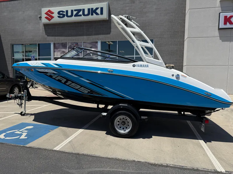 Slide: The Image of 2021 Yamaha AR195 boat on trailer, parked outside Suzuki dealership. - 4