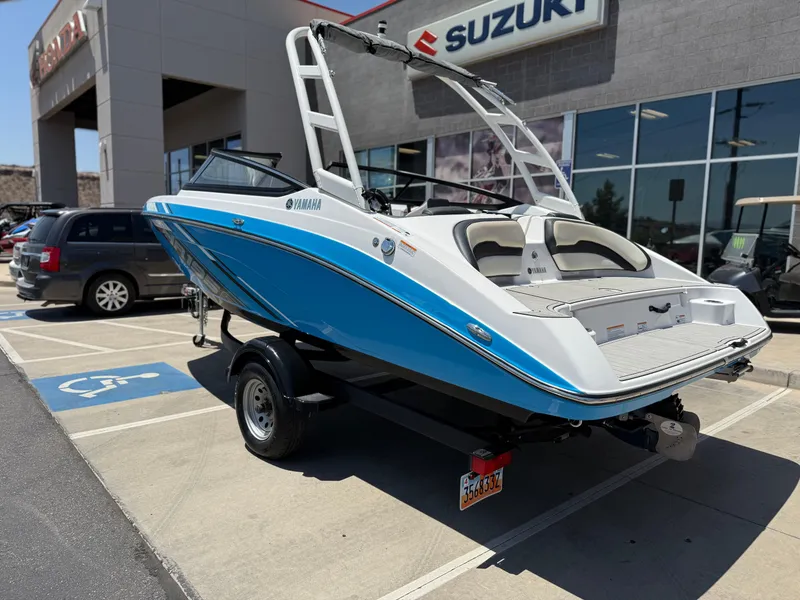 Slide: The Image of 2021 Yamaha AR195 boat in dealership parking lot, blue and white design. - 5