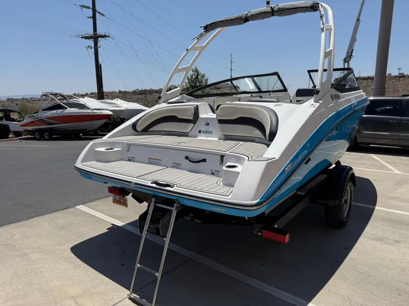 Slide: The Image of 2021 Yamaha AR195 boat on trailer, rear view, in parking lot under clear sky. - 7