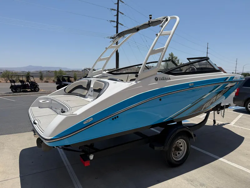 Slide: The Image of 2021 Yamaha Boats AR195 in a parking lot, featuring sleek blue and white design. - 9