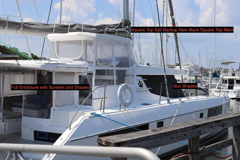 Slide: The Image of 2020 Robertson Leopard catamaran with full enclosure, sun shades, and square top sail, docked at marina. - 2