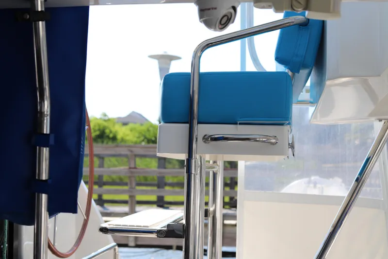 Slide: The Image of Blue cushioned seat on 2020 Robertson Leopard boat, featuring stainless steel frame and outdoor setting. - 23