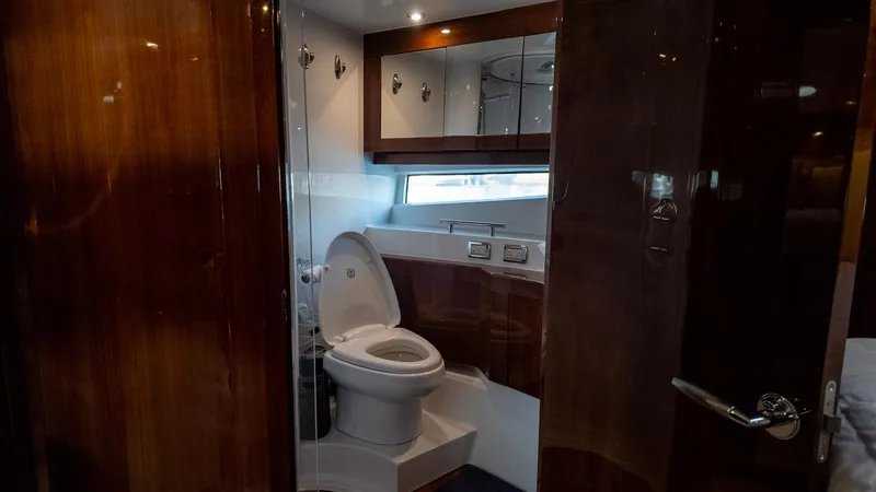 Slide: The Image of Luxurious yacht bathroom with wooden accents, featuring a modern toilet and ample lighting. - 12
