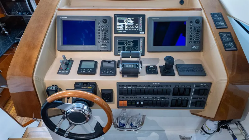Slide: The Image of Control panel of a 2008 Savannah 54 yacht with navigation screens and steering wheel. - 38